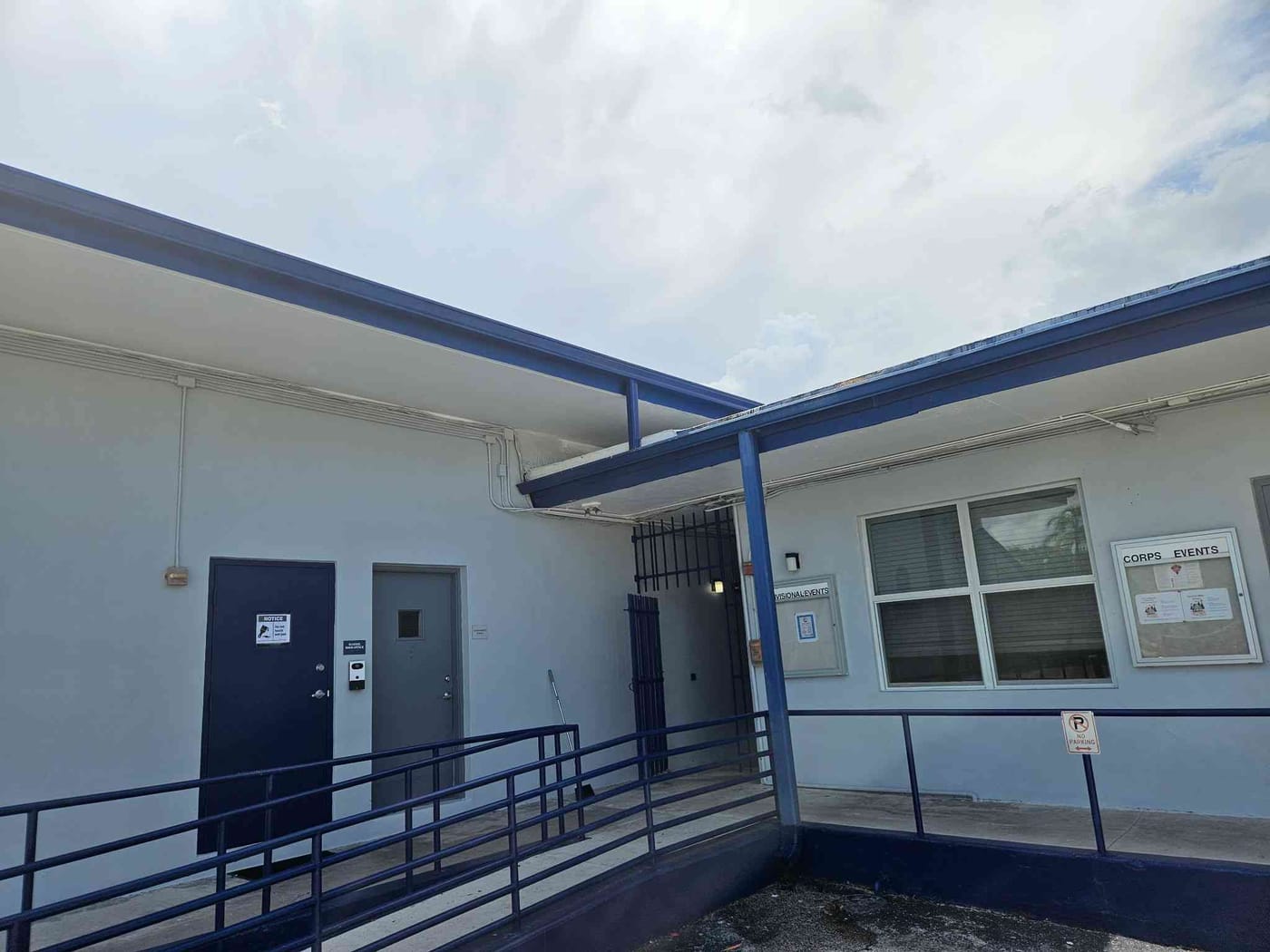 Freshly painted school building exterior with white walls, blue trim and a covered walkway