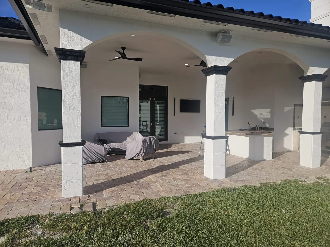 Freshly painted exterior patio with white stucco columns and dark trim