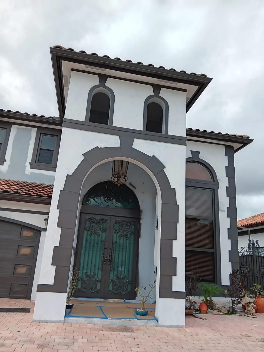 Exterior painting project — taping and priming a stucco wall before topcoat